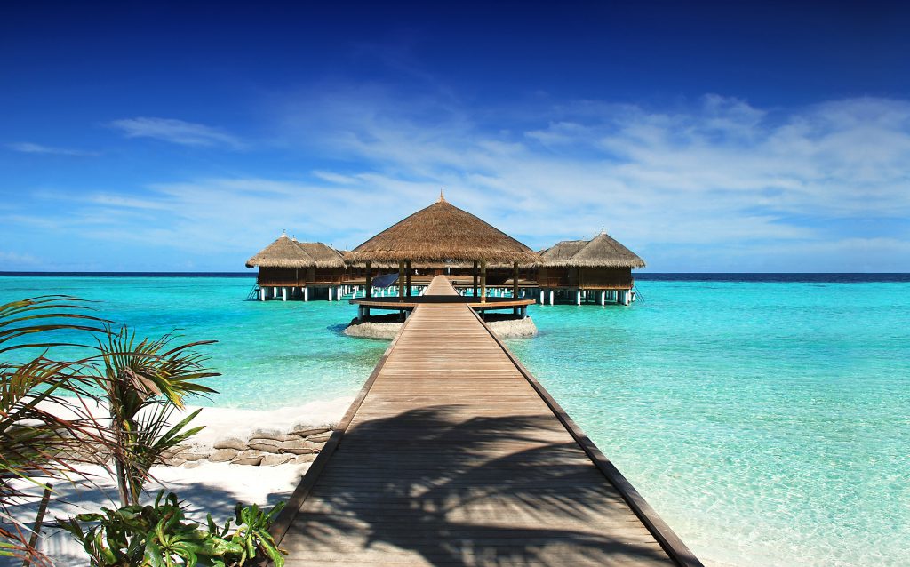 Zatoka na Malediwach z drewnianymi domkami i molo.